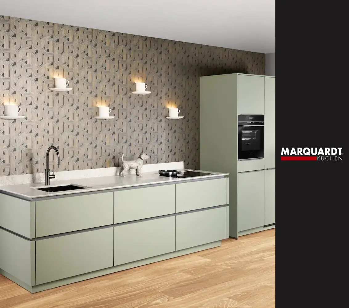 Moderne keukenopstelling van Marquardt Küchen met mintgroene kasten, ingebouwde oven en decoratieve wand met verlichting.